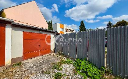 Prenájom garáž, centrum, Spišská Nová Ves - Garáže v Spišskej Novej Vsi s kovovými bránami, vedľa plechového oplotenia, na slnečnom pozemku.