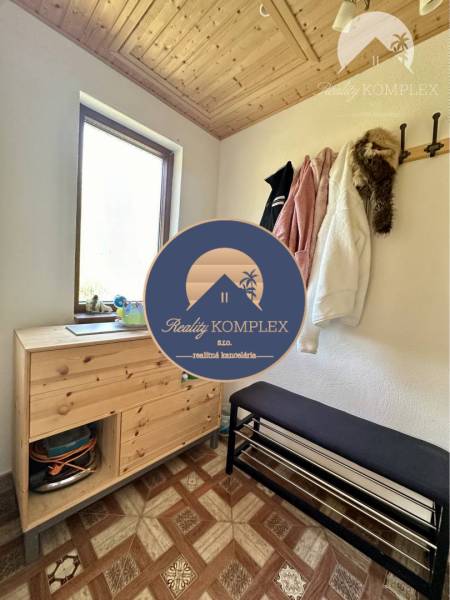 Vám ponúka na predaj rodinný dom v Komárne, ča - Predsieň v rodinnom dome s dreveným stropom, botníkom a vešiakom na kabáty.