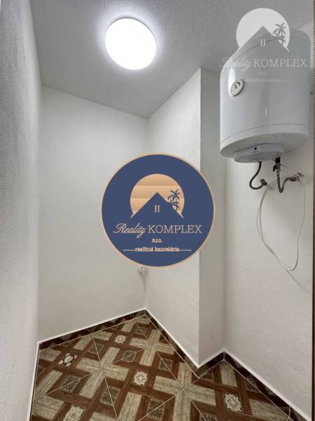Vám ponúka na predaj rodinný dom v Komárne, ča - Úložný priestor v rodinnom dome s keramickou dlažbou a bojlerom na stene.
