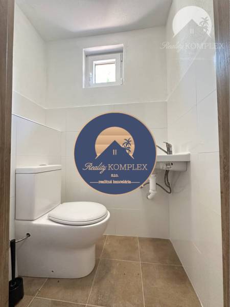 Vám ponúka na predaj rodinný dom v Komárne, ča - Rodinný dom obsahuje toaletu s oknom a podlahou s dreveným dekorom.