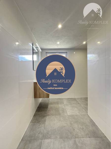 Vám ponúka na predaj rodinný dom v Komárne, ča - Kúpeľňa v rodinnom dome s keramickou dlažbou a svetlými obkladmi.