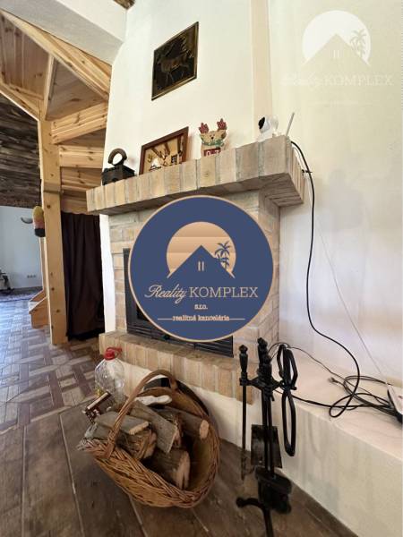Vám ponúka na predaj rodinný dom v Komárne, ča - Krby v rodinnom dome s košíkom na drevo a tehlovým obkladom.