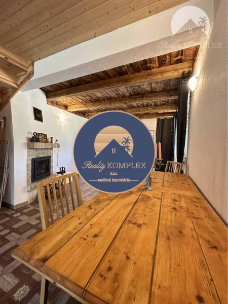 Vám ponúka na predaj rodinný dom v Komárne, ča - Interiér rodinného domu s podlahou s dreveným dekorom a dreveným stropom.