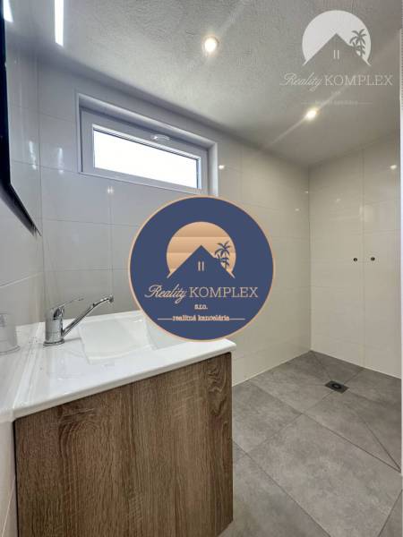 Vám ponúka na predaj rodinný dom v Komárne, ča - Kúpeľňa v rodinnom dome s umývadlom a sprchovým kútom.