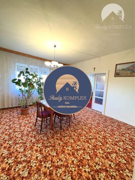 VÝRAZNÁ ZĽAVA !!! MIMORIADNÁ PONUKA!!! Vám pon - Obývačka rodinného domu s kobercovou podlahou a jedálenským stolom.