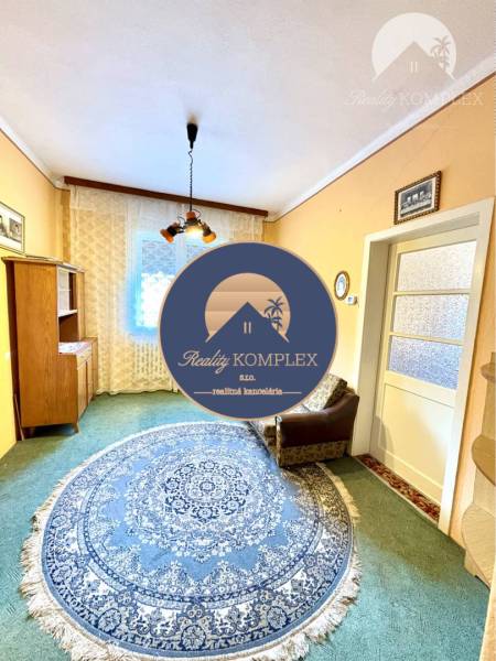 VÝRAZNÁ ZĽAVA !!! MIMORIADNÁ PONUKA!!! Vám pon - Obývacia izba v rodinnom dome s okrúhlym modrým kobercom a kreslom.