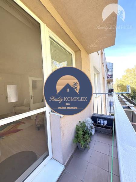 Vám ponúka na PREDAJ tento nádherný, kompletne  - Balkón pri 4-izbovom byte v Komárne s kvetmi a výhľadom na zeleň.