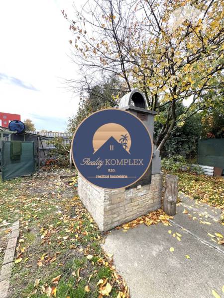 IBA U NÁS !!! ponúka EXKLUZÍVNE na predaj rodin - Záhrada rodinného domu v Komárne so stromami a záhradným grilom z tehlových blokov.