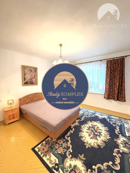 IBA U NÁS !!! ponúka EXKLUZÍVNE na predaj rodin - Spálňa v rodinnom dome so svetlom, kobercom a posteľou, vedľa nočný stolík.