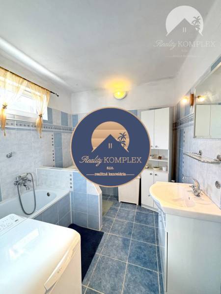 IBA U NÁS !!! ponúka EXKLUZÍVNE na predaj rodin - Kúpeľňa v rodinnom dome s vaňou, práčkou a modrými dlaždicami na stenách a podlahe.