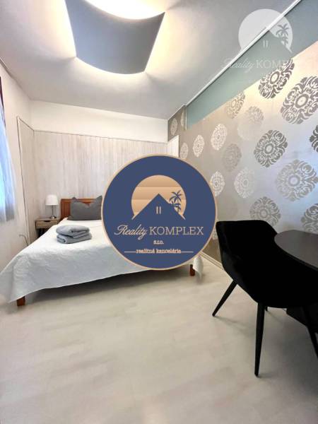 Vám EXKLUZÍVNE ponúka NA PRENÁJOM moderný 2 iz - Svetlá spálňa s posteľou a vzorovanou tapetou v 2-izbovom byte.