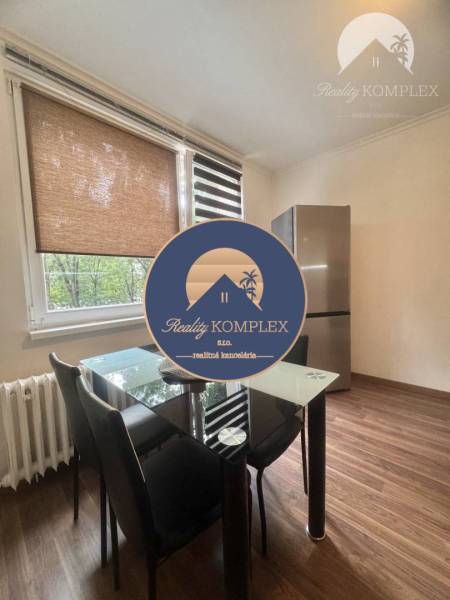 Vám ponúka 1 izbový byt vo VYHĽADÁVANEJ lokali - Jedálenský kút so skleneným stolom a chladničkou, 1-izbový byt, podlaha s dreveným dekorom.