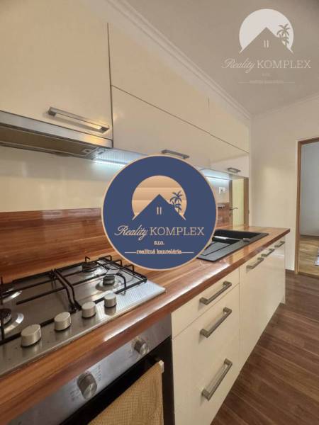 Vám ponúka 1 izbový byt vo VYHĽADÁVANEJ lokali - Kuchynská linka v 1-izbovom byte s podlahou s dreveným dekorom a varnou doskou.