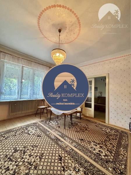 Vám ponúka na predaj 4 izbový rodinný dom  s r - Izba v rodinnom dome s kobercom, lustrom a oknami, ponúka útulný priestor.