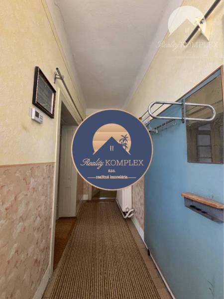 Vám ponúka na predaj 4 izbový rodinný dom  s r - Chodba v rodinnom dome s textúrovanými stenami a kobercovým behúňom.