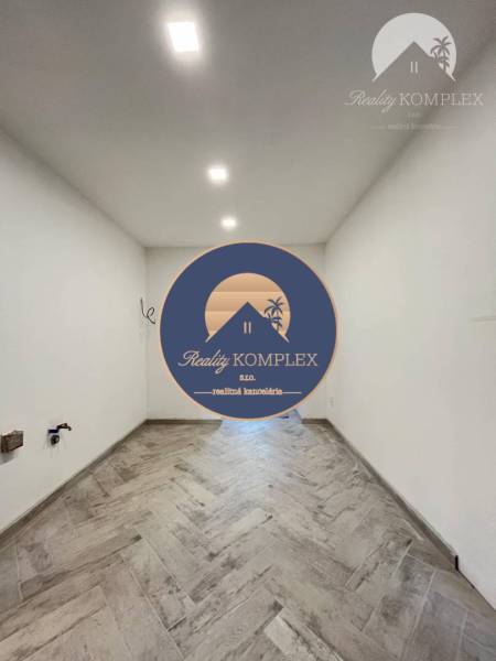 Vám ponúka  na predaj budovu na BÝVANIE aj PODN - Predsieň s dlažbou, bielymi stenami a vstavaným osvetlením v modernizovanej budove.