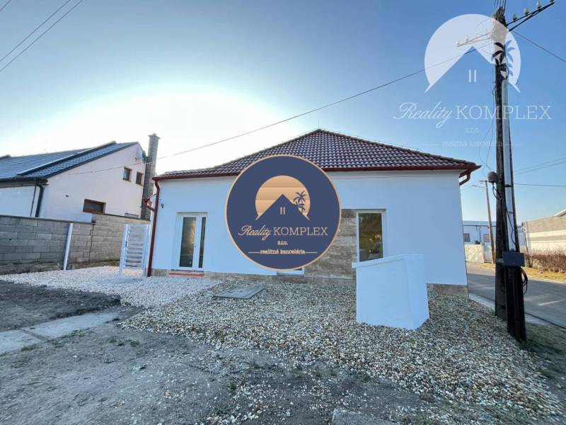 Vám ponúka  na predaj budovu na BÝVANIE aj PODN - Dom s bielou fasádou, šikmou strechou, oknami a bielym kamienkovým chodníkom pred ním.