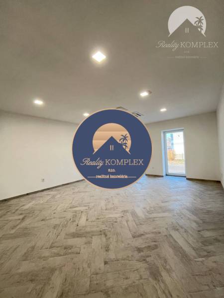 Vám ponúka  na predaj budovu na BÝVANIE aj PODN - Priestranná miestnosť s bielymi stenami a drevenou podlahou v budove.