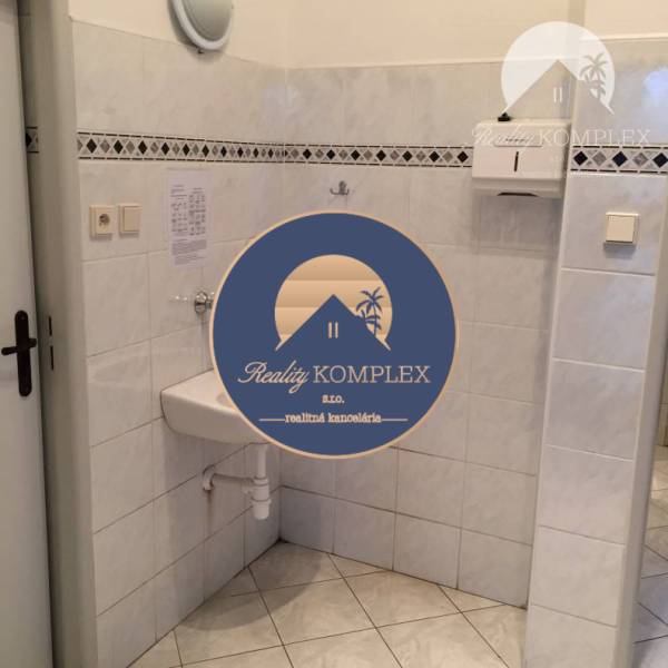 Vám ponúka do PRENÁJMU priestranné a slnečné ob - Interiér obchodných priestorov s umývadlom a obkladom v neutrálnych farbách.