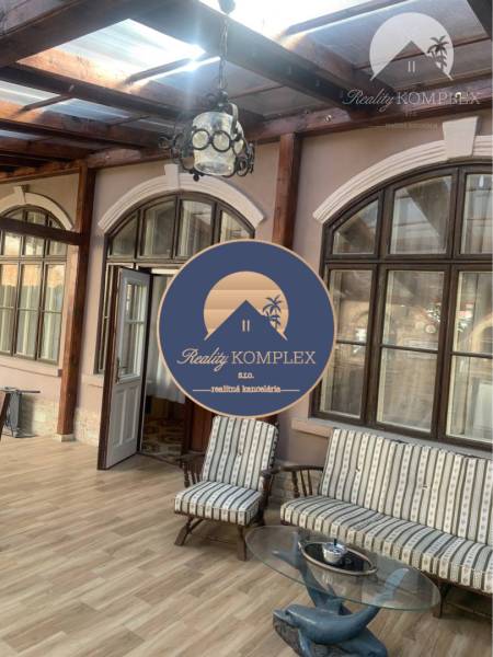 Vám ponúka do PRENÁJMU čarovný, úplne zrekonštr - Presklená veranda v rodinnom dome s dreveným dekorom a vintage sedačkami.