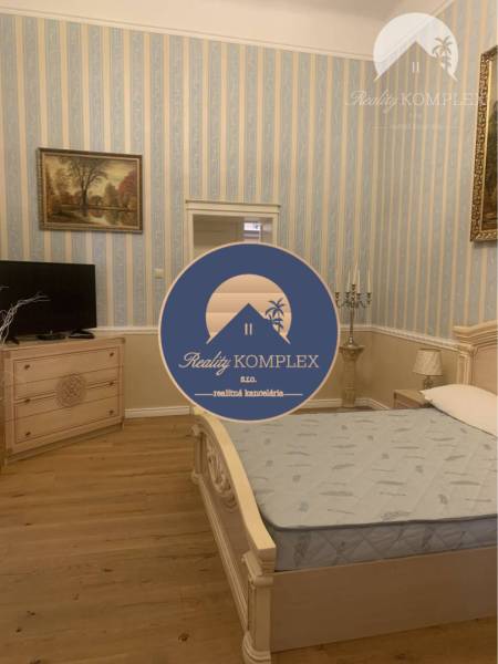 Vám ponúka do PRENÁJMU čarovný, úplne zrekonštr - Spálňa s posteľou, komodou, tapetami a podlahou s dreveným dekorom v rodinnom dome.