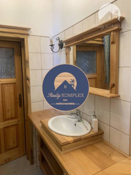 Vám ponúka do PRENÁJMU čarovný, úplne zrekonštr - Kúpeľňa v rodinnom dome s keramickým umývadlom, dreveným dekorom a nástenným svietidlom.