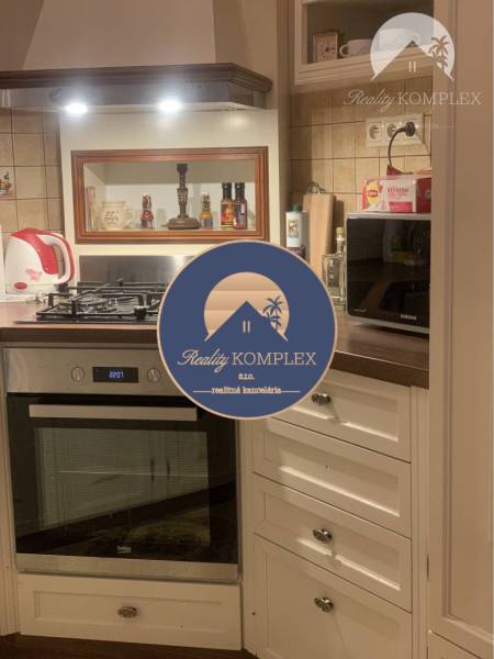 Vám ponúka do PRENÁJMU čarovný, úplne zrekonštr - Kuchyňa v rodinnom dome s bielymi skrinkami, rúrou a zabudovaným digestorom.