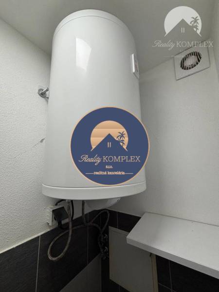 Vám ponúka exkluzívne na predaj moderný, komple - Elektrický bojler v kúpeľni 1-izbového bytu zobrazujúci detaily inštalácie.