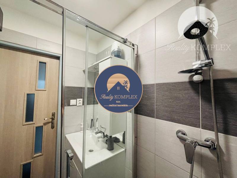Vám ponúka exkluzívne na predaj moderný, komple - Kúpeľňa v 1-izbovom byte s moderným sprchovým kútom a umývadlom.
