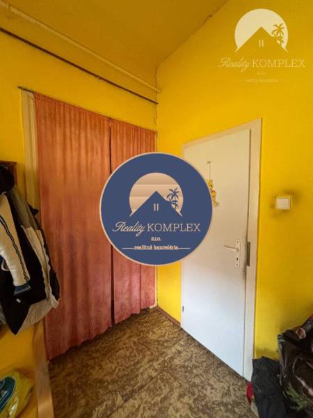 Reality KOMPLEX Vám ponúka EXKLUZÍVNE na predaj rodinný dom, ktorý sa  - Predsieň v rodinnom dome s pestro žltými stenami a podlahou s dreveným dekorom.