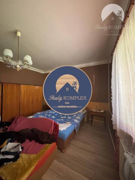 Reality KOMPLEX Vám ponúka EXKLUZÍVNE na predaj rodinný dom, ktorý sa  - Spálňa v rodinnom dome, obsahuje postele, skrine a podlahu s dreveným dekorom.