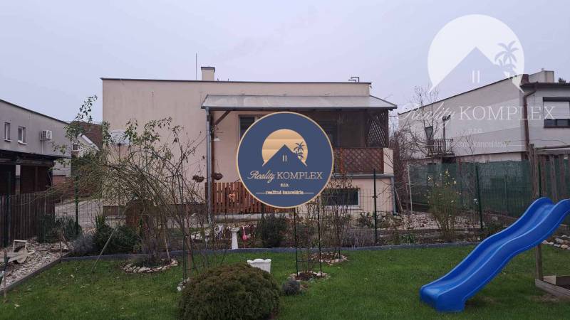 !!! LEN U NÁS!!! Vám ponúka NA PREDAJ rodinný d - Rodinný dom v Kostolných Kračanoch na Hlavnej ulici s trávnikom a modrou šmykľavkou.