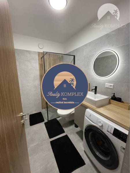 Vám ponúka na Prenájom 2-izbový byt s loggiou  - Kúpeľňa v 2-izbovom byte s práčkou, kruhovým zrkadlom a sprchovým kútom.