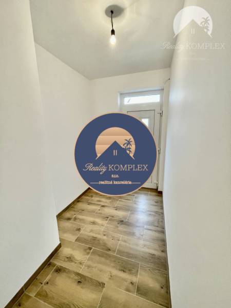 Vám ponúka modernú 4-izbovú novostavbu v Dunajs - Chodba v rodinnom dome s podlahou s dreveným dekorom a bielymi stenami.