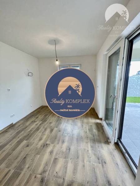 Vám ponúka modernú 4-izbovú novostavbu v Dunajs - Interiér rodinného domu s podlahou s dreveným dekorom a výhľadom na záhradu.