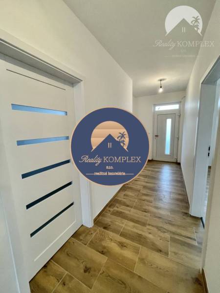 Vám ponúka modernú 4-izbovú novostavbu v Dunajs - Chodba v rodinnom dome s bielymi dverami a podlahou s dreveným dekorom.