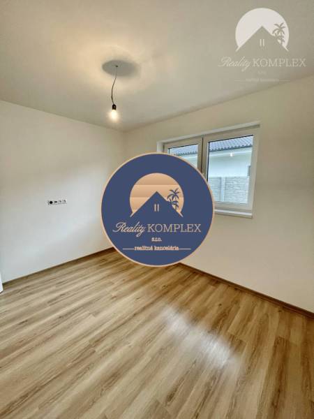 Vám ponúka modernú 4-izbovú novostavbu v Dunajs - Izba v rodinnom dome s podlahou s dreveným dekorom a jednoduchým osvetlením.