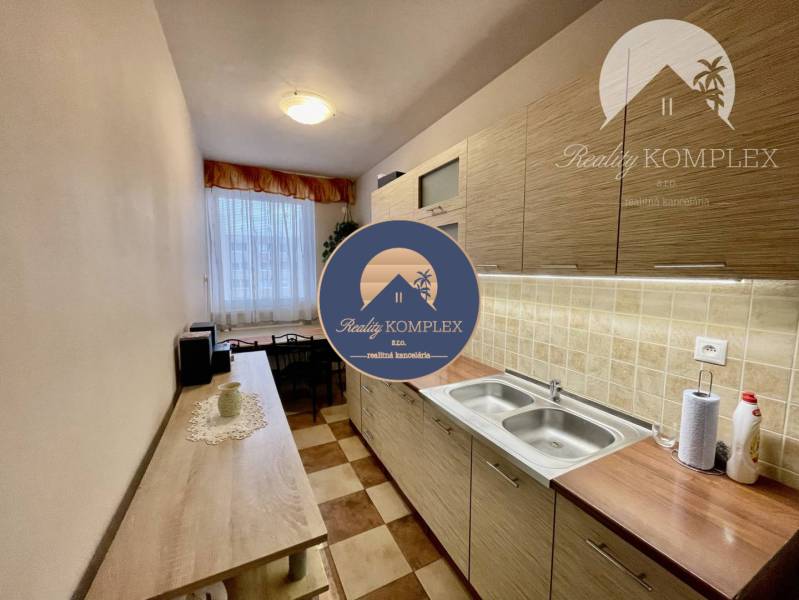 Vám ponúka 3-izbový byt s loggiou po kompletnej - Kuchyňa v 3-izbovom byte s dlažbou, linkou a vstavanými skrinkami vrátane dekorácií.