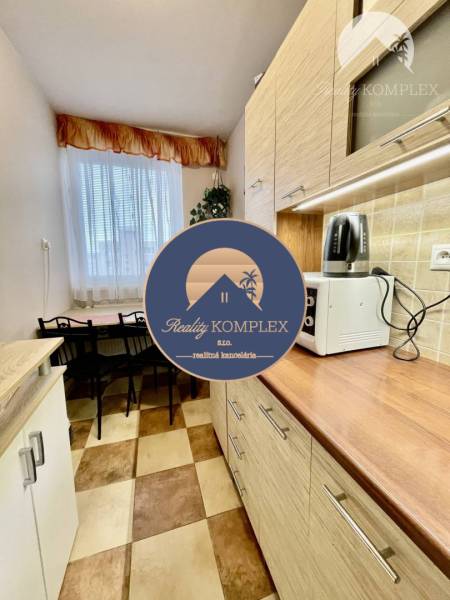 Vám ponúka 3-izbový byt s loggiou po kompletnej - Kuchyňa v 3-izbovom byte s podlahou s dreveným dekorom, svetlá výbava.