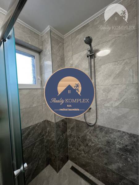 Vám ponúka na PREDAJ kompletne zrekonštruovaný  - Sprchový kút v rodinnom dome s mramorovým obkladom a modernou sprchovou hlavicou.