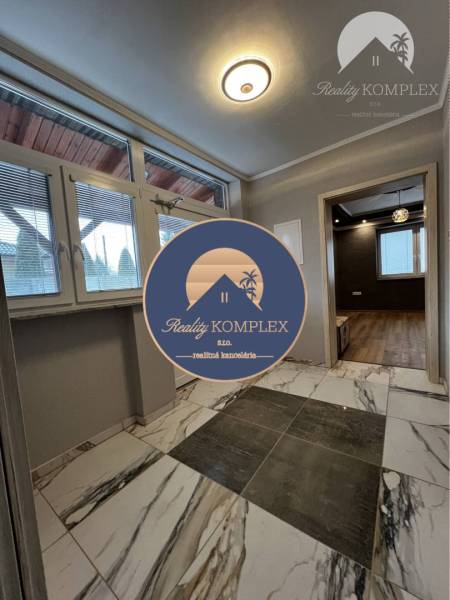 Vám ponúka na PREDAJ kompletne zrekonštruovaný  - Vstupná chodba rodinného domu s keramickou dlažbou a veľkým oknom.