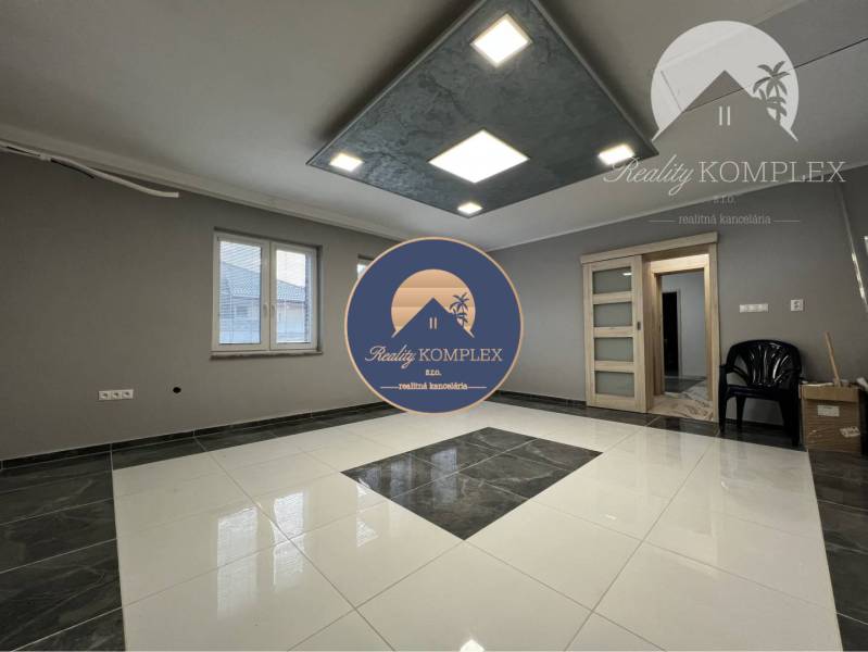 Vám ponúka na PREDAJ kompletne zrekonštruovaný  - Obývacia izba v rodinnom dome s dlažbou a šedými stenami.