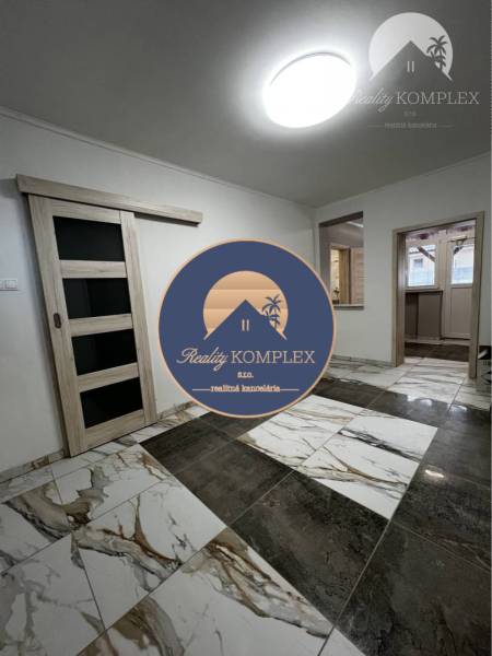 Vám ponúka na PREDAJ kompletne zrekonštruovaný  - Interiér rodinného domu s posuvnými dverami a podlahou s mramorovým vzorom.