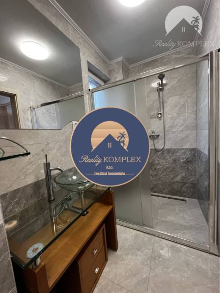 Vám ponúka na PREDAJ kompletne zrekonštruovaný  - Kúpeľňa v rodinnom dome s veľkým zrkadlom, skleným umývadlom a sprchovým kútom.