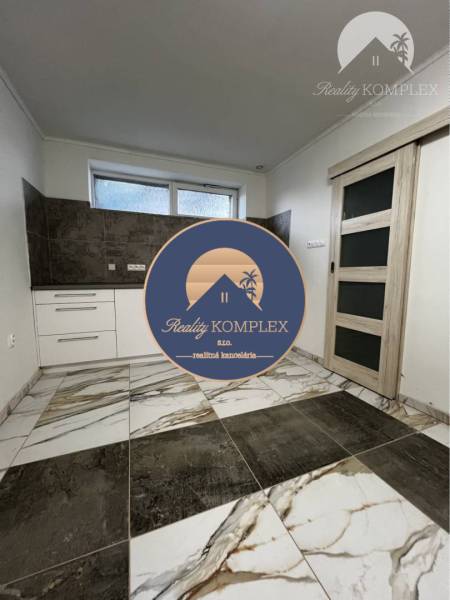 Vám ponúka na PREDAJ kompletne zrekonštruovaný  - Interiér v rodinnom dome s dlažbou a kuchynským kútom v jemných farbách.