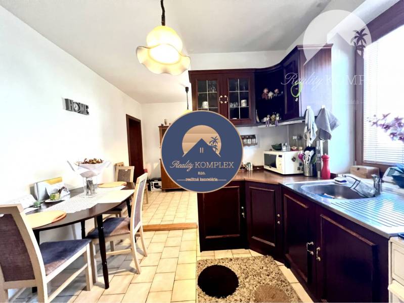 Ponúka na PREDAJ zrekonštruovaný 5 izbový podpi - Kuchyňa s jedálňou v rodinnom dome s dreveným nábytkom a keramickou dlažbou.