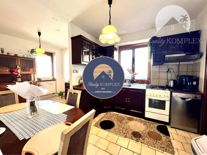 Ponúka na PREDAJ zrekonštruovaný 5 izbový podpi - Jasná kuchyňa so sporákom a jedálenským stolom v rodinnom dome.