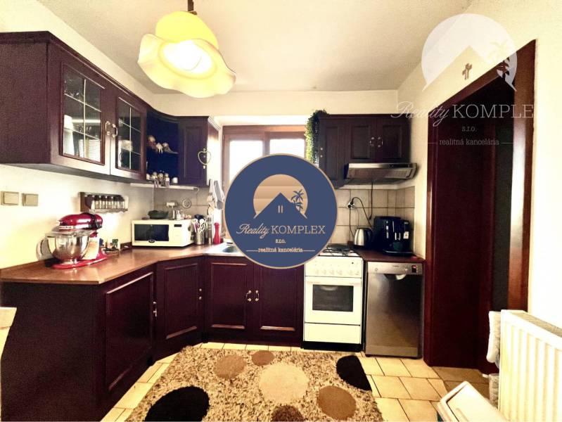 Ponúka na PREDAJ zrekonštruovaný 5 izbový podpi - Kuchyňa v rodinnom dome s drevenou skrinkou a modernými spotrebičmi.