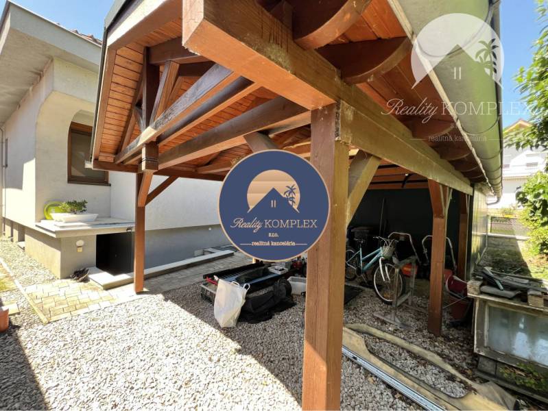 Ponúka na PREDAJ zrekonštruovaný 5 izbový podpi - Drevený prístrešok vedľa rodinného domu v Topoľníkoch so skladom a bicyklami.