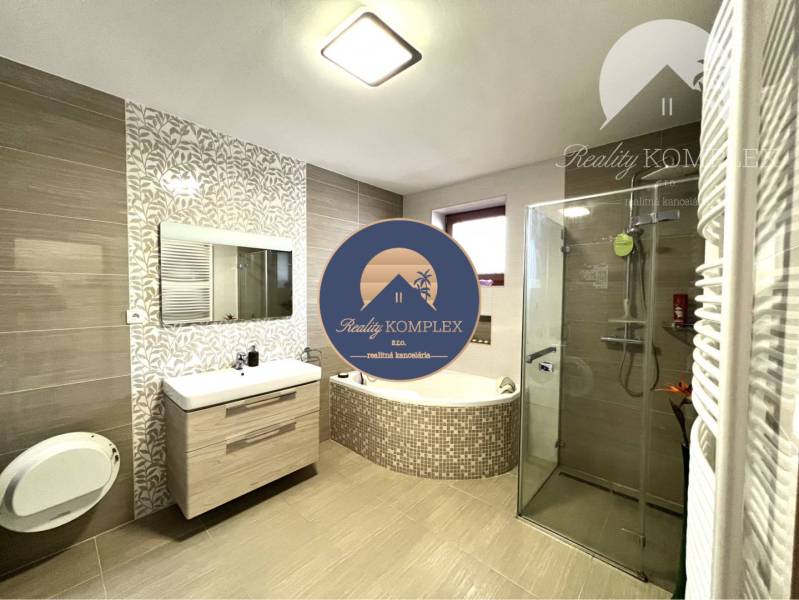 Ponúka na PREDAJ zrekonštruovaný 5 izbový podpi - Kúpeľňa v rodinnom dome s vaňou, sprchou a elegantným obkladom.